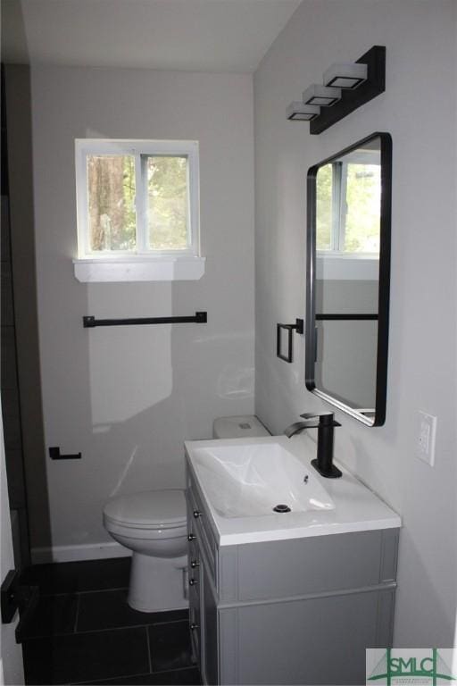 bathroom featuring tile patterned flooring, vanity, and toilet