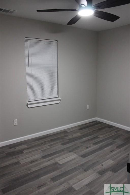 empty room featuring wood finished floors, baseboards, a ceiling fan, and visible vents