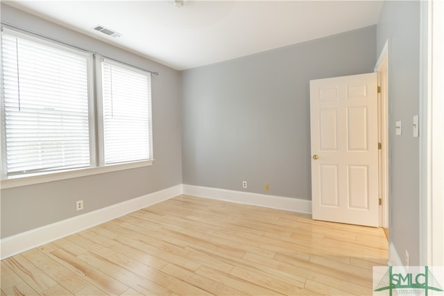 unfurnished room featuring a wealth of natural light and light hardwood / wood-style flooring