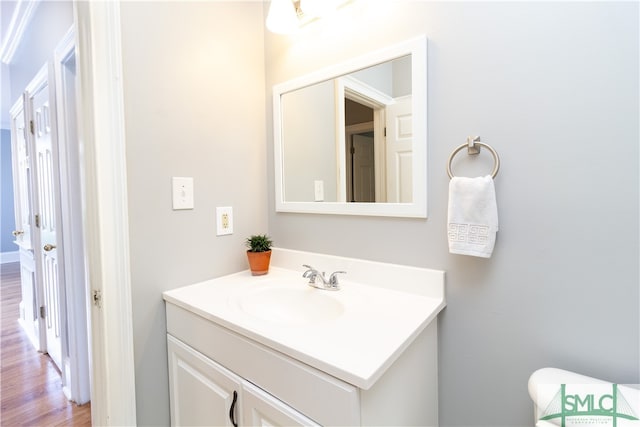 bathroom featuring vanity, hardwood / wood-style floors, and toilet