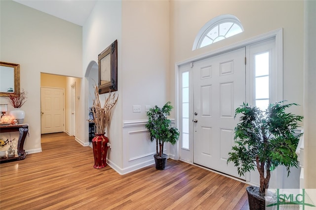 foyer entrance featuring high vaulted ceiling and light wood-type flooring