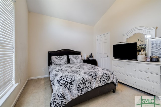 bedroom featuring lofted ceiling and light carpet