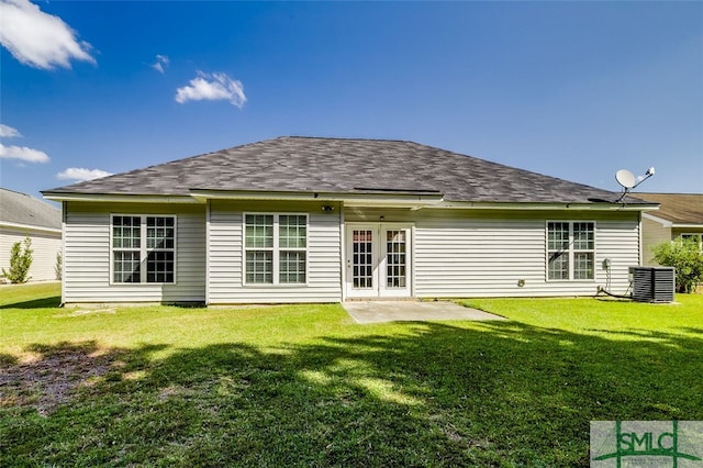 rear view of house with cooling unit and a lawn