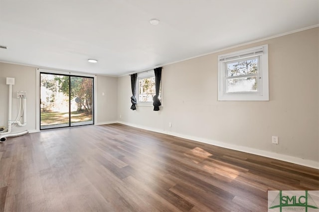 unfurnished room with wood-type flooring, a wealth of natural light, and ornamental molding