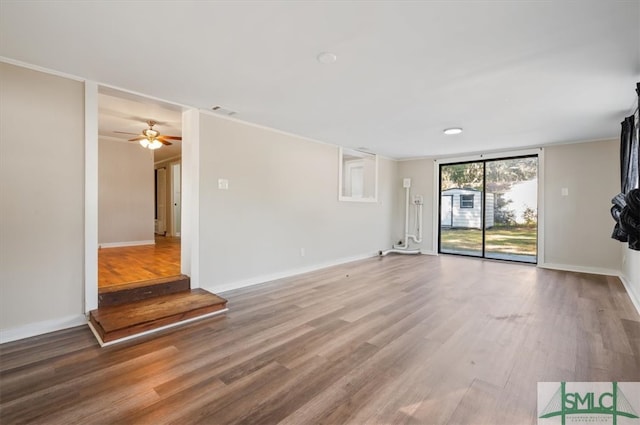 unfurnished living room featuring crown molding, ceiling fan, and wood-type flooring