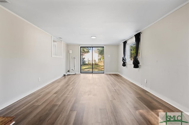 unfurnished room featuring hardwood / wood-style floors and ornamental molding