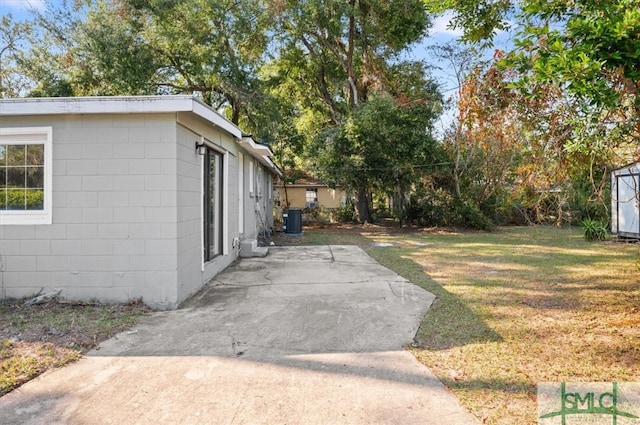 view of yard with central air condition unit and a patio