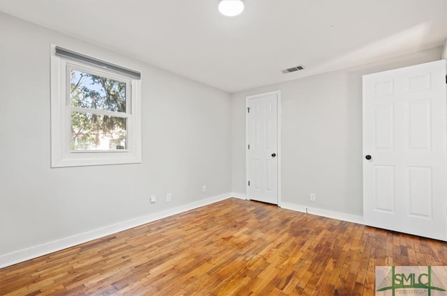 unfurnished room with hardwood / wood-style flooring