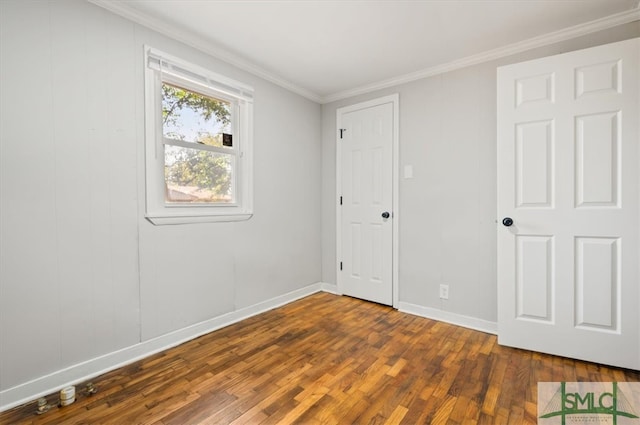 spare room with dark hardwood / wood-style floors and crown molding