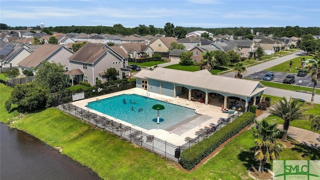 view of swimming pool featuring a water view, a patio area, and a yard