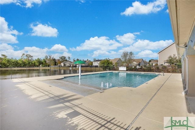 view of swimming pool with a water view and a patio