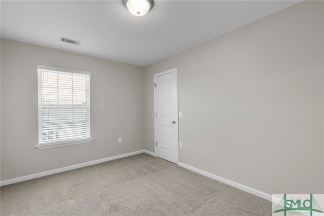 carpeted spare room featuring a textured ceiling