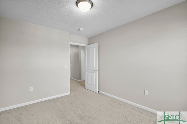 carpeted empty room with a textured ceiling