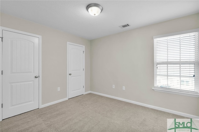 unfurnished bedroom with light carpet