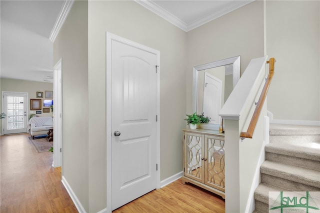 foyer with ornamental molding and light wood-type flooring