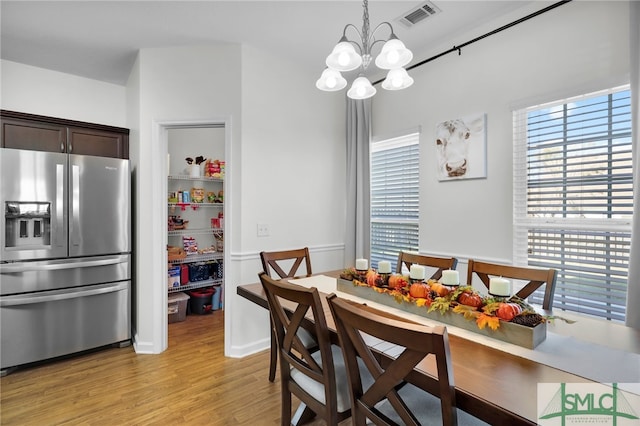 dining space with a notable chandelier and light wood-type flooring