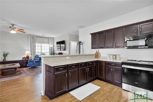 kitchen with light wood-type flooring, stainless steel electric range, kitchen peninsula, and ceiling fan