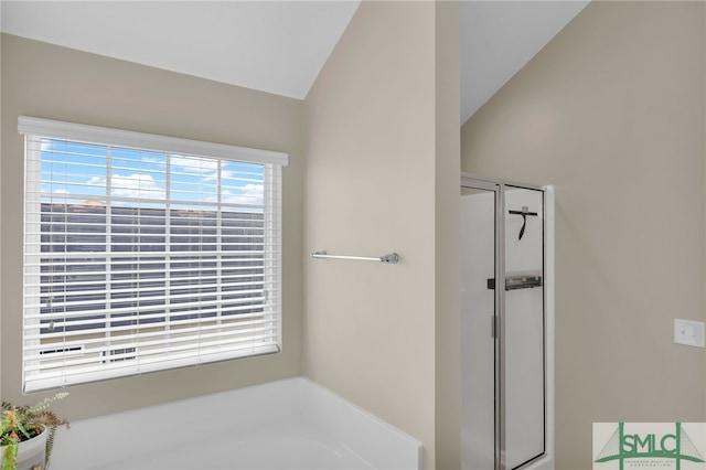 bathroom with shower with separate bathtub and vaulted ceiling