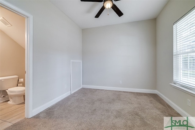 carpeted empty room with ceiling fan and a healthy amount of sunlight