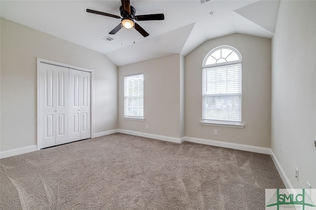 unfurnished bedroom with multiple windows, lofted ceiling, and ceiling fan