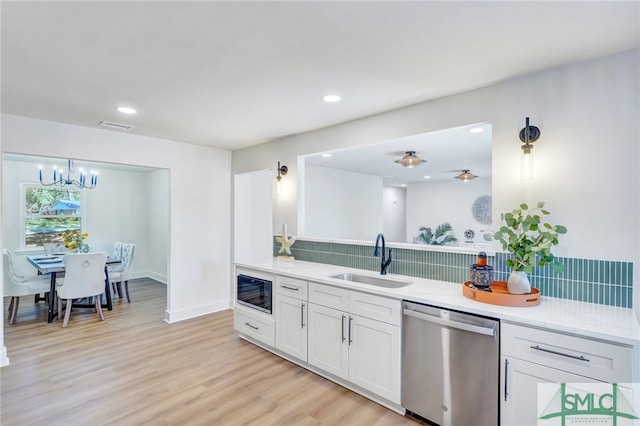 kitchen featuring sink, stainless steel dishwasher, a chandelier, white cabinets, and light hardwood / wood-style floors