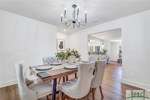 dining space with a notable chandelier and hardwood / wood-style floors