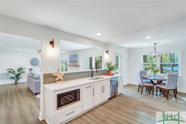 kitchen featuring white cabinetry, dishwasher, a healthy amount of sunlight, and sink