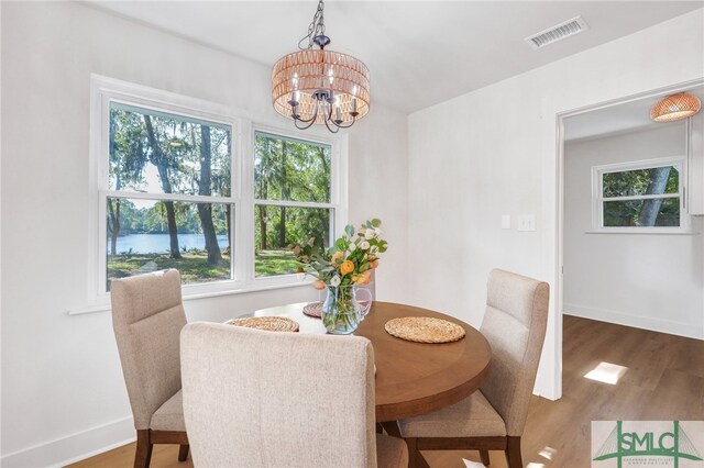 dining room featuring wood-type flooring and an inviting chandelier