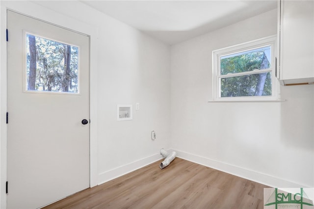 clothes washing area with light hardwood / wood-style floors, washer hookup, and a wealth of natural light