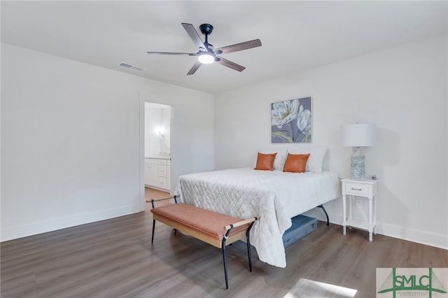 bedroom with ceiling fan, ensuite bath, and dark hardwood / wood-style floors