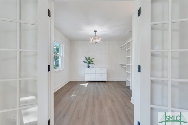 interior space with light hardwood / wood-style floors and an inviting chandelier