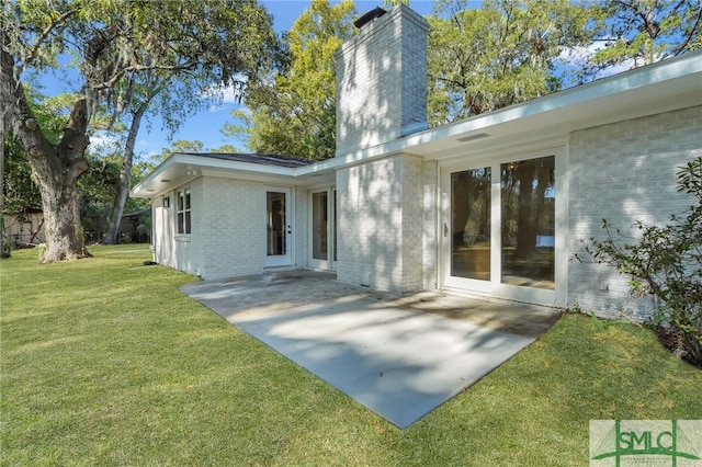 rear view of house with a patio area and a lawn