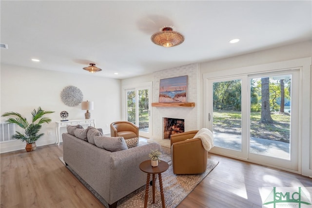 living room with a large fireplace and light wood-type flooring