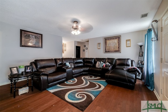 living room with ceiling fan, a textured ceiling, and dark hardwood / wood-style flooring