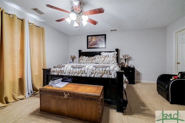 bedroom with a textured ceiling, carpet floors, and ceiling fan