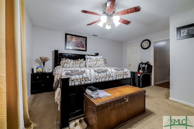 carpeted bedroom featuring a textured ceiling and ceiling fan