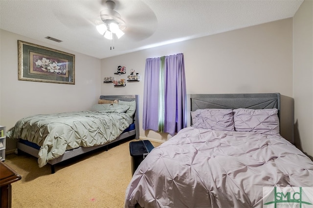 bedroom featuring a textured ceiling, carpet, and ceiling fan