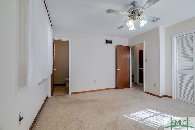 unfurnished bedroom featuring a closet, ceiling fan, connected bathroom, and light colored carpet