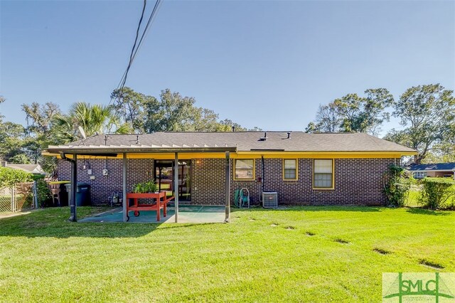 rear view of house with a patio, central AC, and a lawn