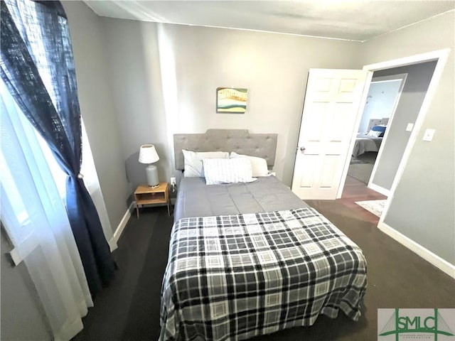 bedroom with baseboards and multiple windows