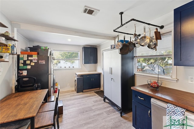 kitchen with blue cabinetry, light wood-type flooring, and a healthy amount of sunlight