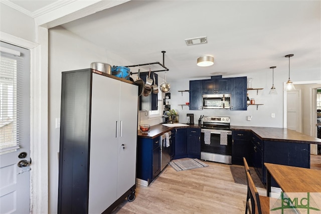 kitchen with crown molding, light wood-type flooring, stainless steel appliances, pendant lighting, and blue cabinetry