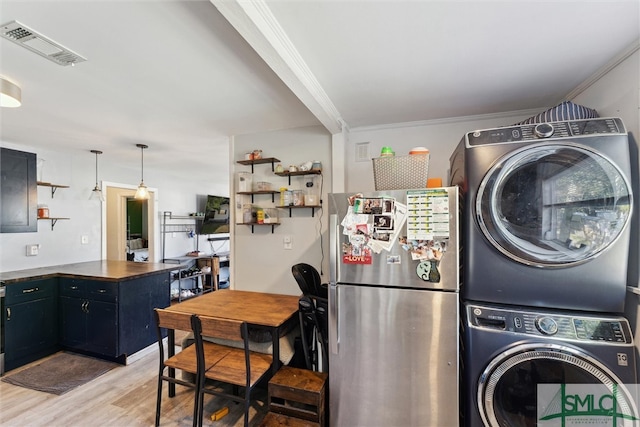 washroom featuring light hardwood / wood-style flooring, stacked washer / dryer, and crown molding