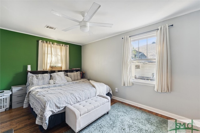 bedroom featuring dark hardwood / wood-style flooring, crown molding, and ceiling fan