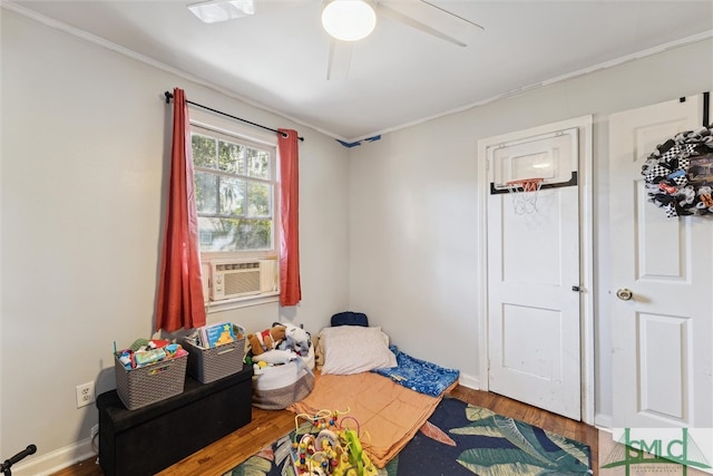 interior space featuring ornamental molding, cooling unit, wood-type flooring, and ceiling fan