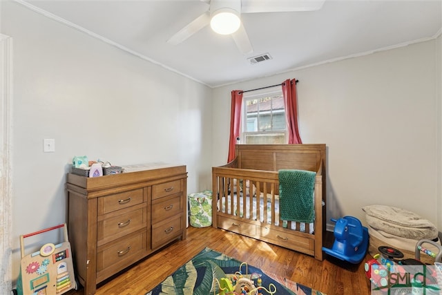 bedroom featuring ceiling fan, ornamental molding, and light wood-type flooring