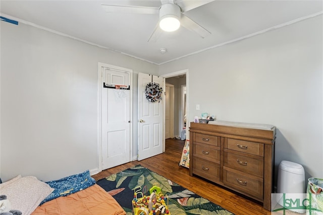 bedroom with ceiling fan, ornamental molding, and dark hardwood / wood-style floors