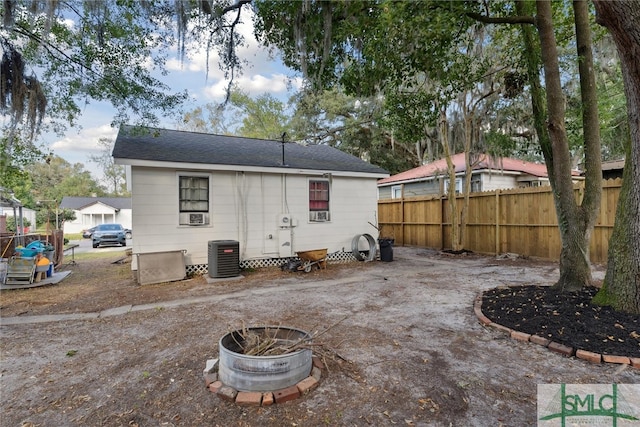 rear view of house featuring a patio area, cooling unit, and a fire pit