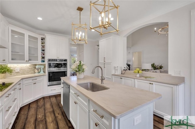 kitchen with appliances with stainless steel finishes, a kitchen island with sink, white cabinetry, and a sink