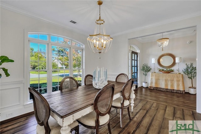 dining area featuring visible vents, a chandelier, hardwood / wood-style floors, and ornamental molding